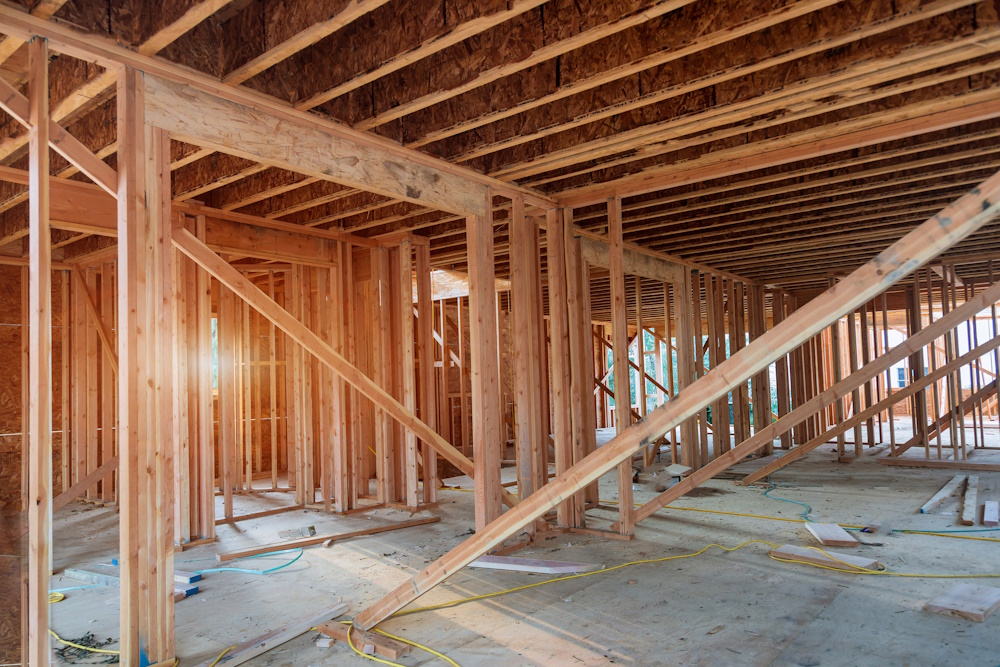 New construction of beam construction house framed the ground up framing against a blue sky