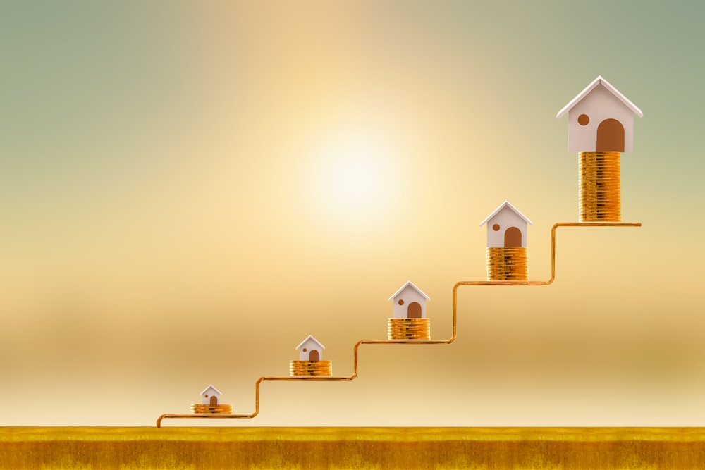 Stacking five gold coin with growing on golden steps and home as destinations on sunlight background, Loan for real estate or buy a new house in the future concept.