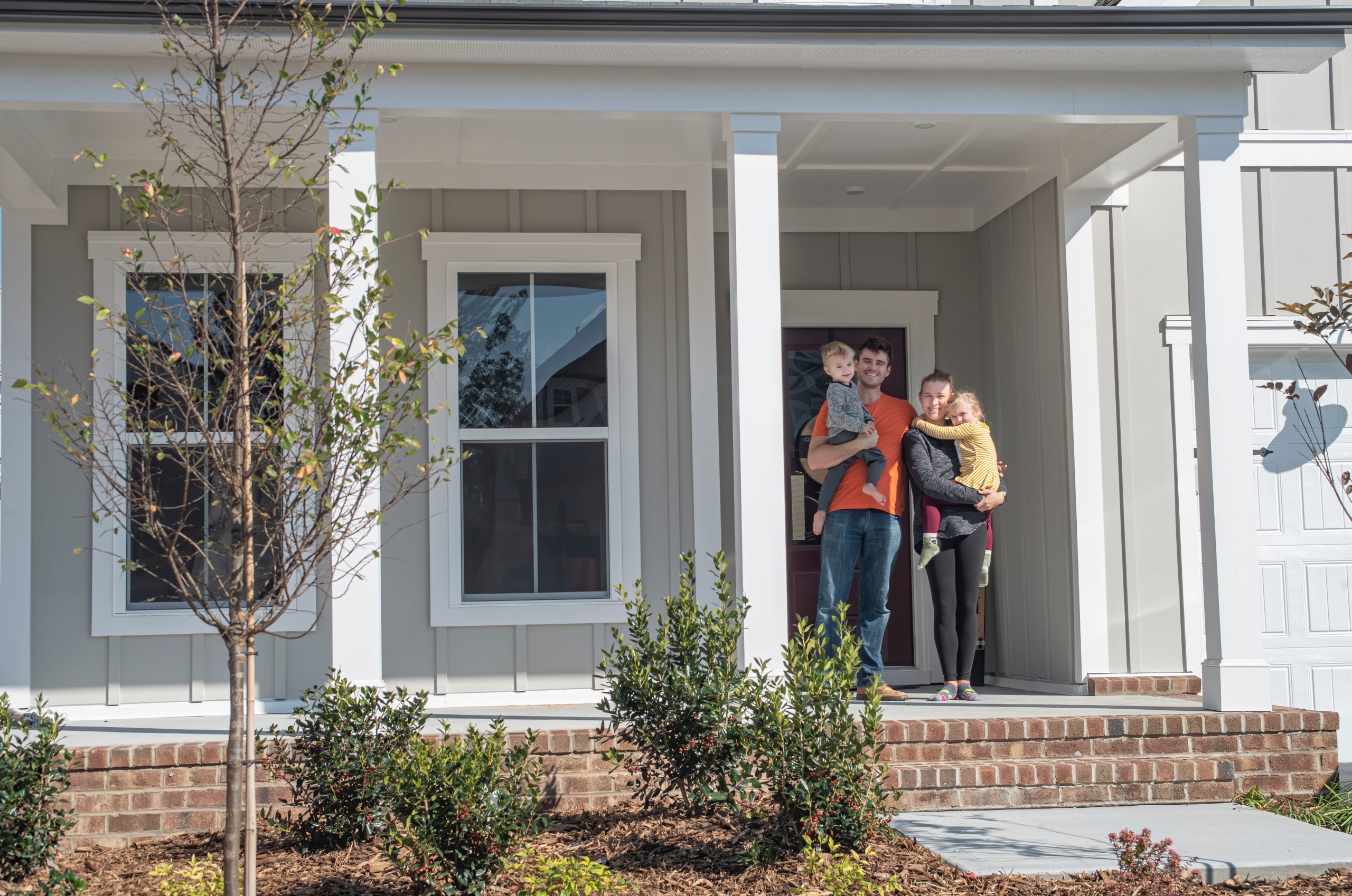 Family on the porch of their new first home.